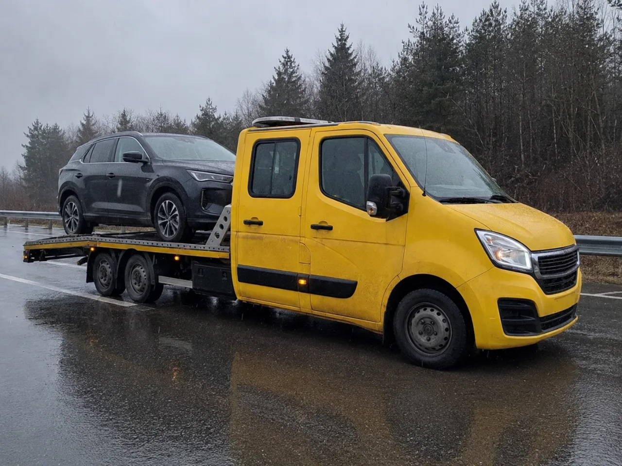 Holowanie srebrnego SUV-a na lawecie w deszczu – Olkusz